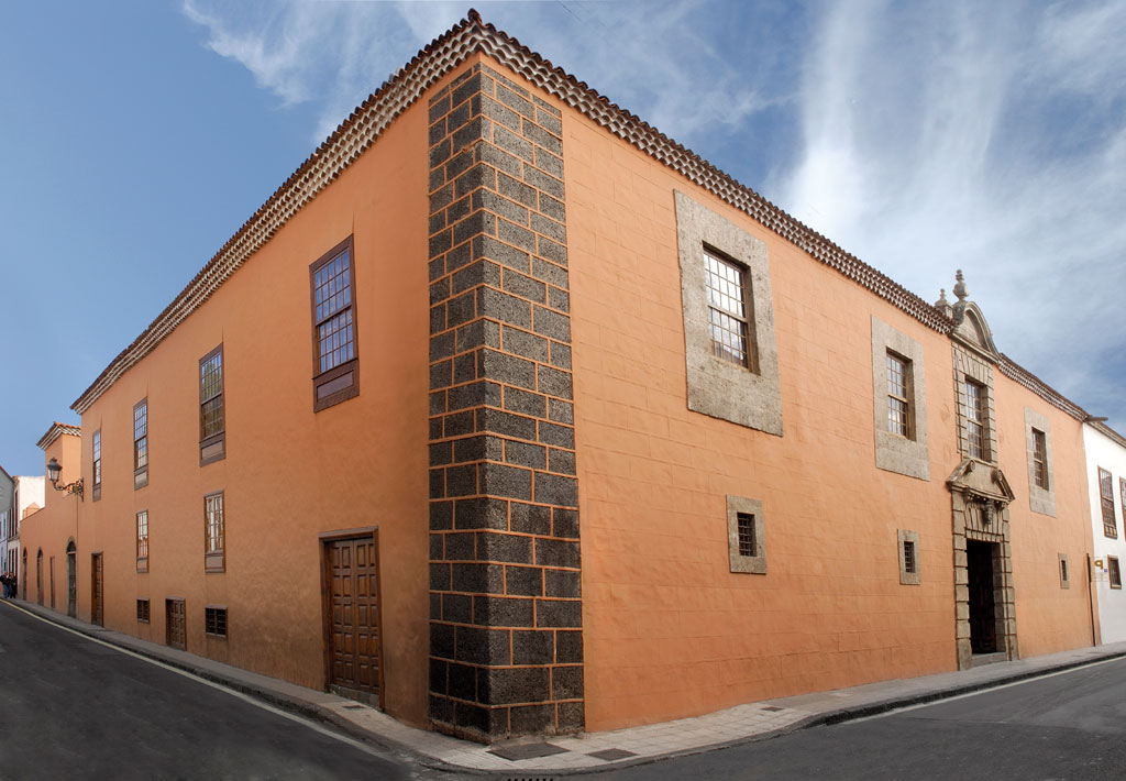 Historisches Gebäude mit orangefarbener Fassade an einer Straße in La Laguna, Teneriffa.