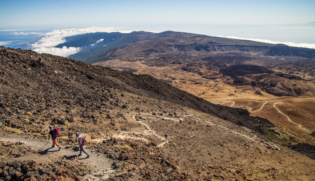 Wanderer auf dem Teideberg, Teneriffa, mit vulkanischer Landschaft im Hintergrund.