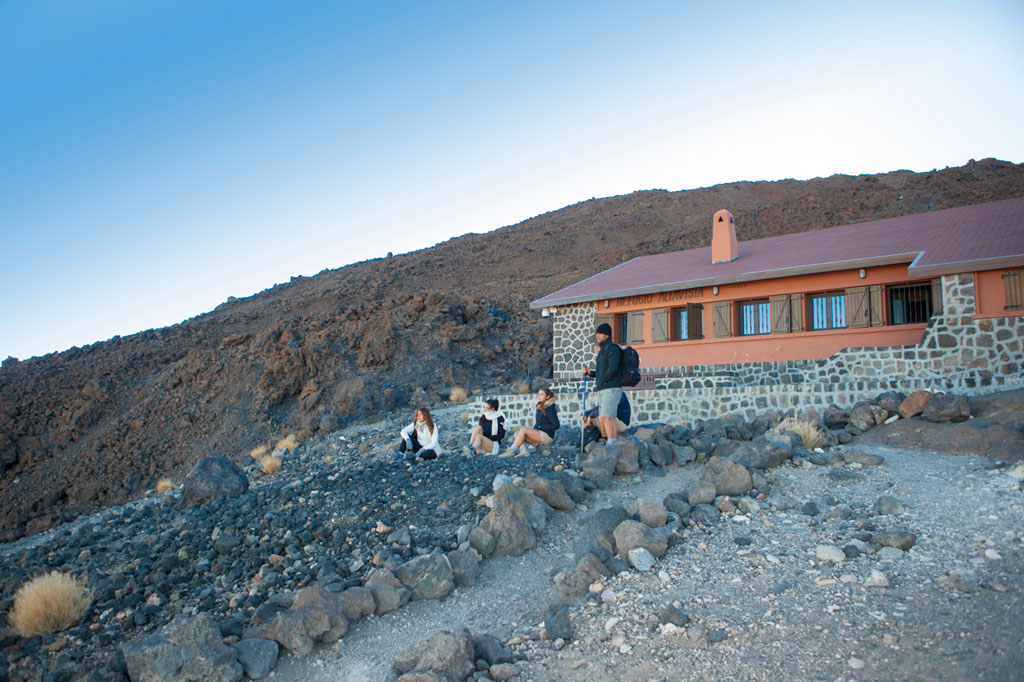 Menschen ruhen vor dem Altavista-Refugium im Nationalpark Teide auf Teneriffa.
