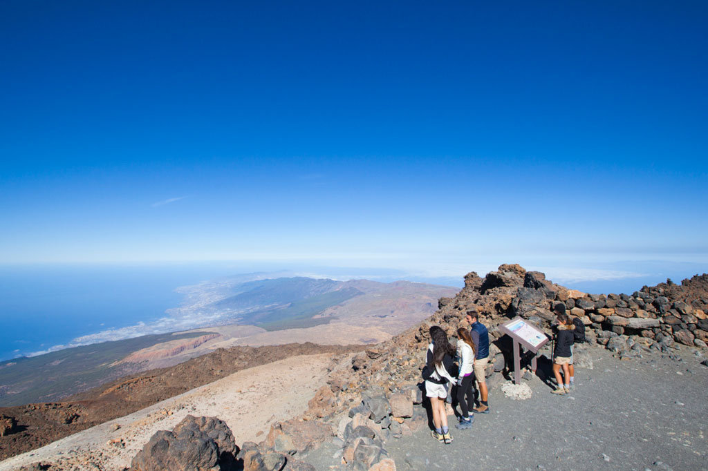 Menschen, die ein Informationsplakat in der Landschaft des Berges Teide auf Teneriffa lesen.