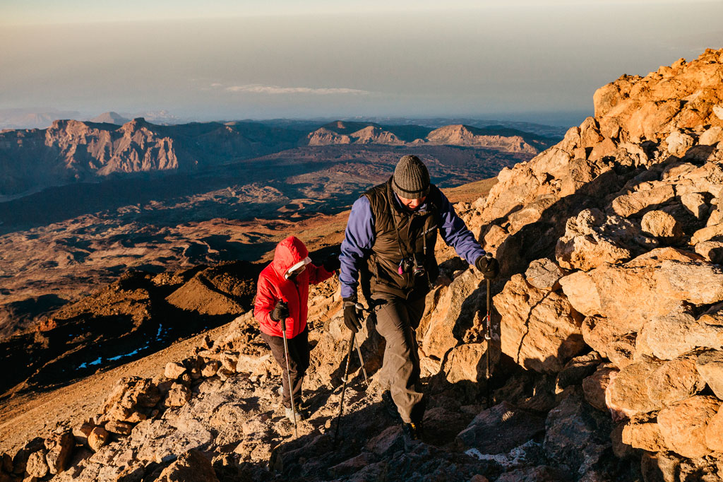 Menschen, die auf dem Teide auf Teneriffa klettern, mit bergiger Landschaft im Hintergrund.