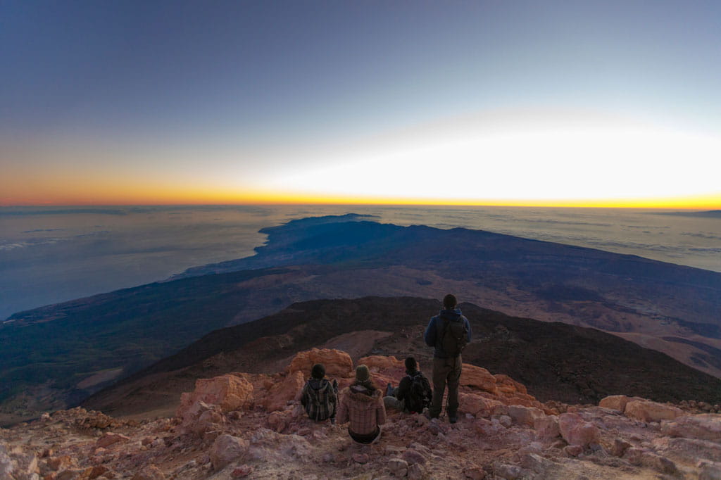 Die Menschen beobachten den Sonnenaufgang vom Gipfel des Montes Teide auf Teneriffa.