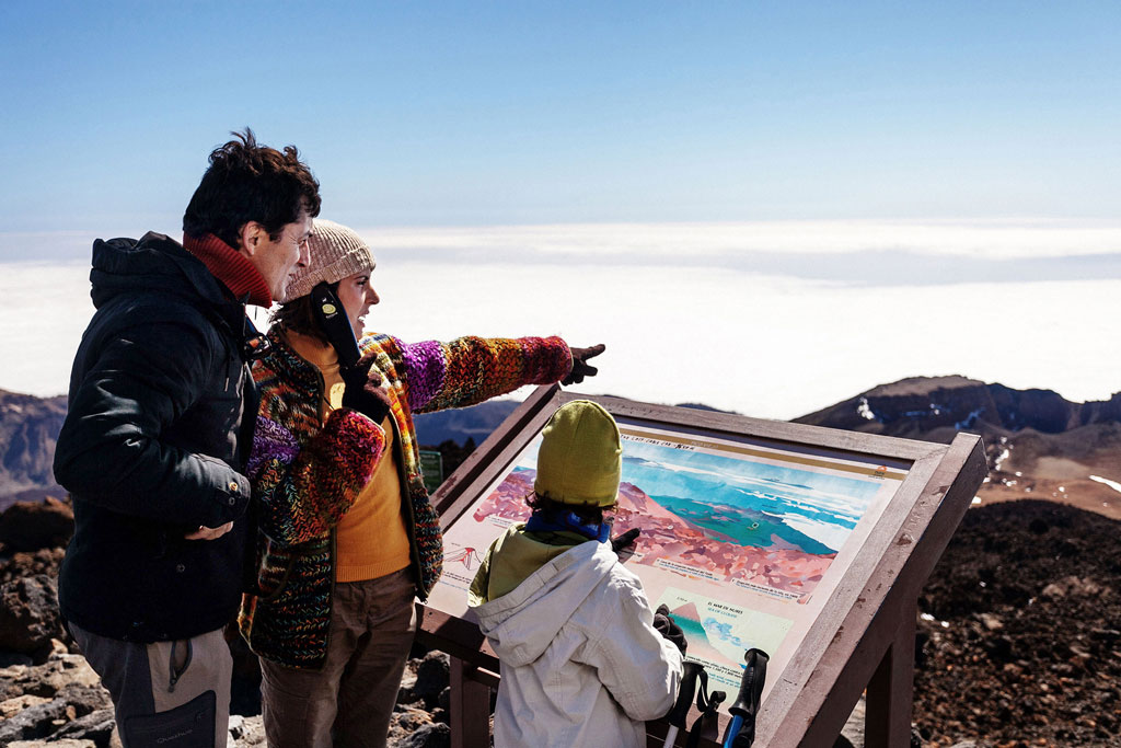 Die Familie betrachtet eine Karte im Nationalpark Teide auf Teneriffa.