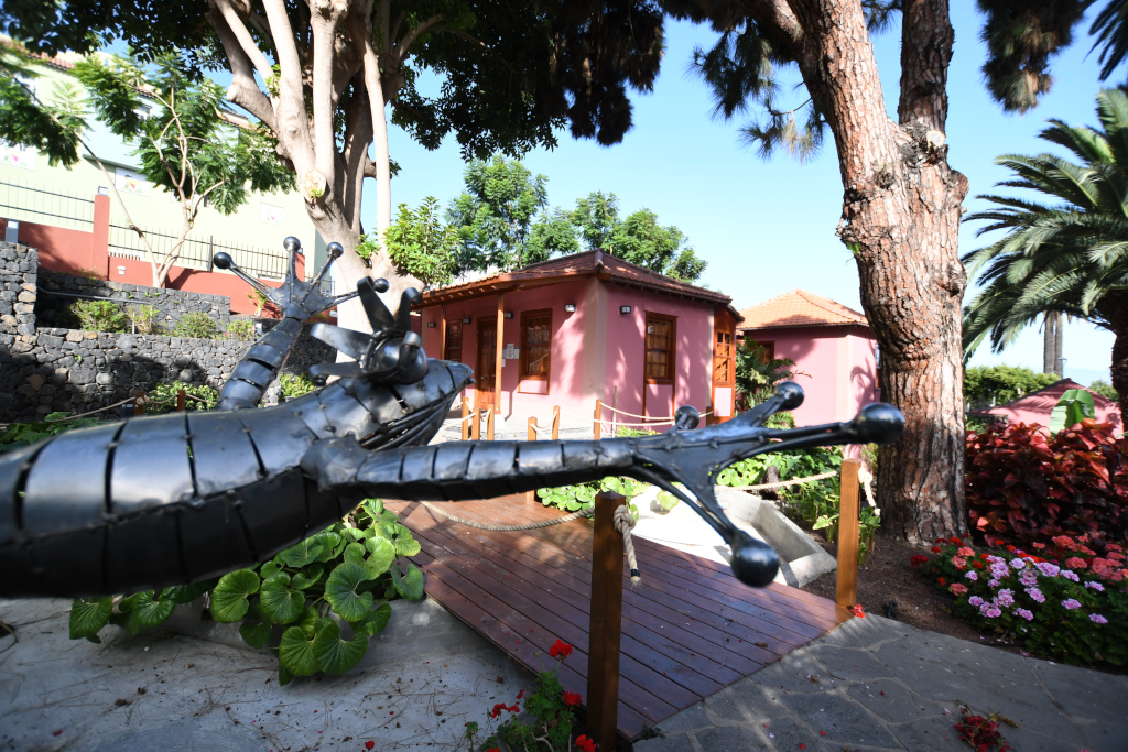 Metallische Eidechsenskulptur vor einem rosa Haus in Puerto de la Cruz, Teneriffa.