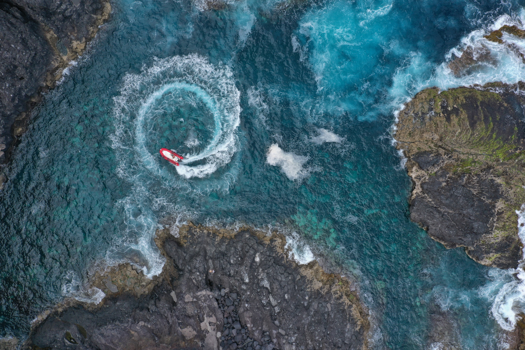 Rotes Boot macht Kreise in den Küstengewässern von Teneriffa.