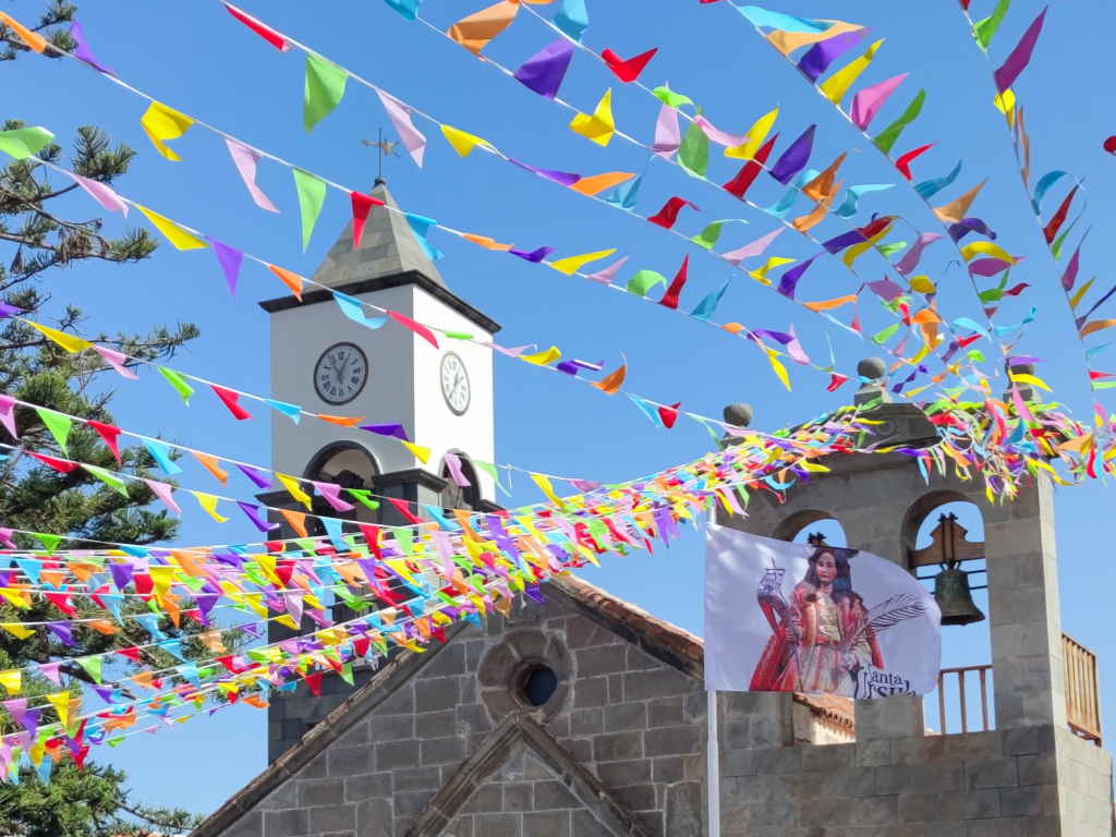 Kirchturm auf Teneriffa mit farbenfrohen Wimpeln und der Flagge der Santa Úrsula.