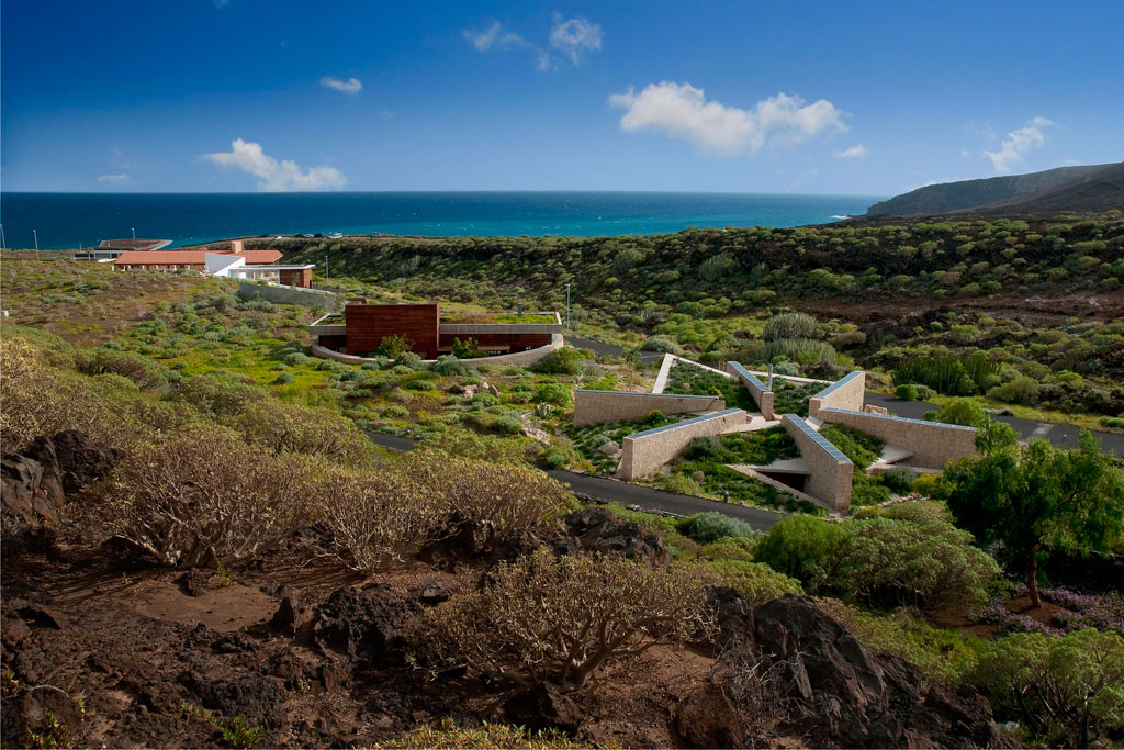 Besucherzentrum in Punta de Teno, Teneriffa, umgeben von Grün und Meer im Hintergrund.
