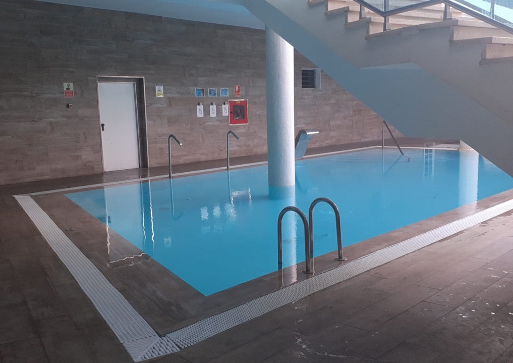 Hallenbad mit Treppen und Schildern an der Wand auf Teneriffa.