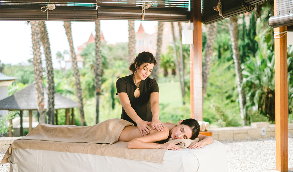 Masseurin, die in einem Outdoor-Spa auf Teneriffa eine Massage durchführt.