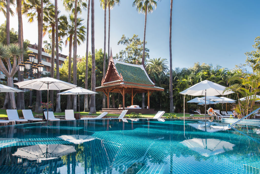 Schwimmbad mit Sonnenschirmen und eine Cabana im orientalischen Stil in einem Hotel auf Teneriffa.