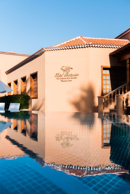 Gebäude mit Schwimmbad, das die Fassade des Hotels Botánico auf Teneriffa widerspiegelt.