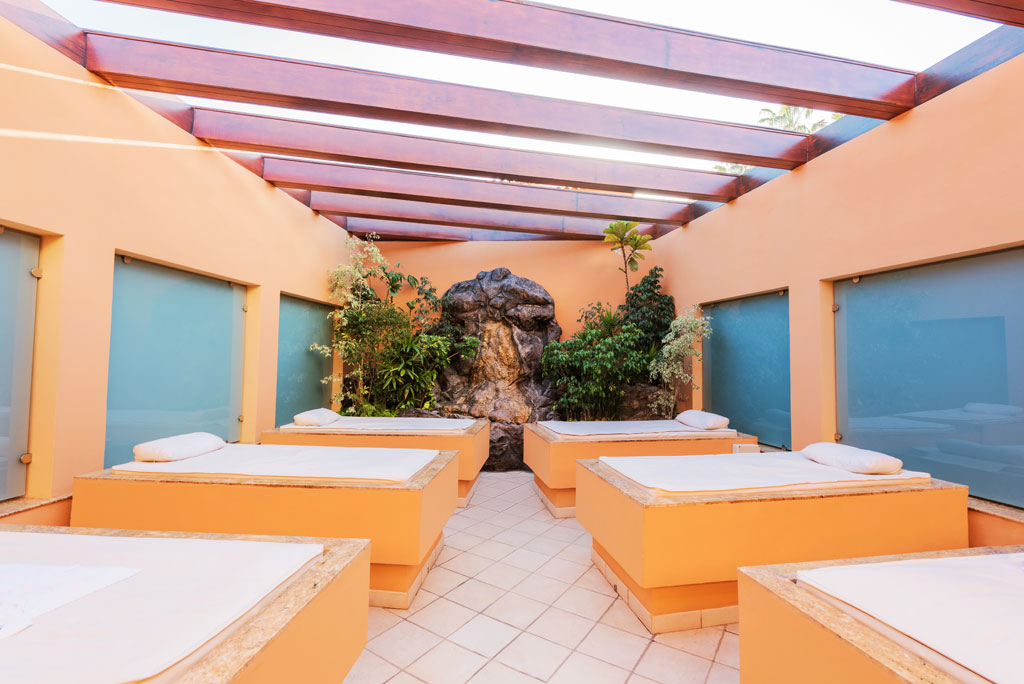 Spa-Betten in einer Indoor-Lounge auf Teneriffa, umgeben von Pflanzen und natürlichem Licht.