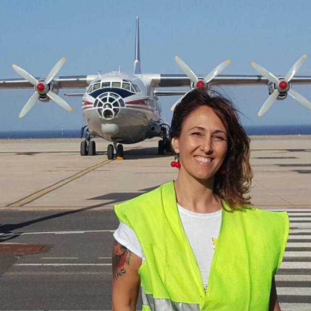Eine Person, die eine reflektierende Weste vor einem Flugzeug auf dem Rollfeld des Flughafens Teneriffa trägt.
